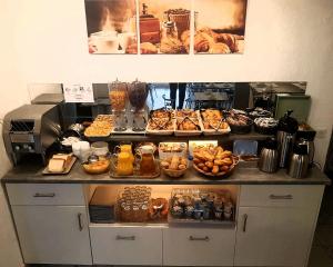 a counter with many different types of food on it at Hotel Les Palmiers En Camargue in Saintes-Maries-de-la-Mer