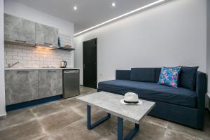 a living room with a blue couch and a table at Il Grigio Apartments in Limenaria