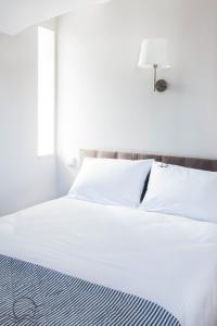 ステグナにあるSłoneczna - Komfortowe Pokoje i Apartamentyの- 白いベッド(ランプ付)