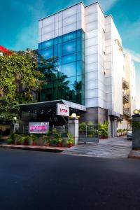 a large glass building with a sign in front of it at The Lotus Apartment hotel, Burkit Road in Chennai