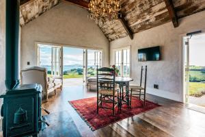 a living room with a table and a fireplace at Mudbrick Cottages in Oneroa