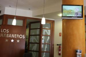 a tv hanging from a wall in a hospital lobby at Hotel Los Habaneros in Cartagena