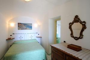 1 dormitorio con cama y espejo en la pared en That's Atrani, en Atrani