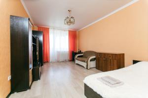 タンボフにあるApartment PrezentHaus Karla Marksa 175k3のベッド、テレビ、椅子が備わる客室です。
