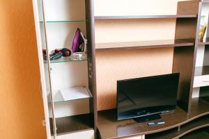 タンボフにあるApartment PrezentHaus Karla Marksa 175k3のデスク、テレビ、棚が備わる客室です。