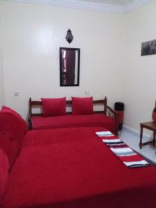 - une chambre avec un lit rouge et un canapé dans l'établissement La Perle, à Meknès