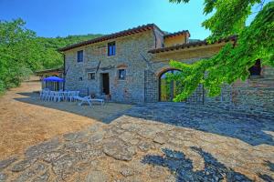 a stone house with a picnic table in front of it at Villa Poggio Conca by PosarelliVillas in Incisa in Valdarno