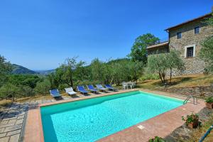 a swimming pool with chairs and a house at Villa Poggio Conca by PosarelliVillas in Incisa in Valdarno