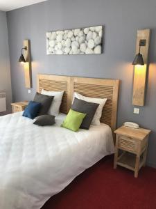 1 dormitorio con 1 cama blanca grande y 4 almohadas en Hôtel des Dunes Noirmoutier, en La Guérinière