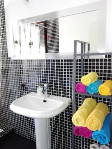 a bathroom with a sink and a mirror and towels at Casa La Rosa de los Vientos in Cobisa +21 photos