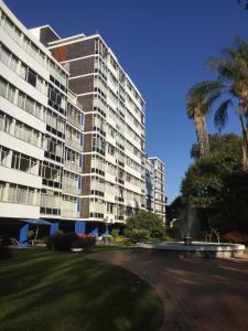 a large building with palm trees in front of it at Northworld in Harare