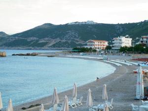 a beach with chairs and umbrellas and the ocean at Apartments Dubrava 106 in Dobra Voda