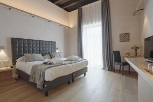 a bedroom with a large bed and a large window at Alba Palace Hotel in Favara