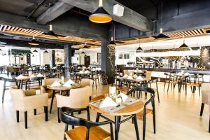 un restaurante con mesas y sillas y un bar en Golden Tulip Essential Tangerang en Tangerang