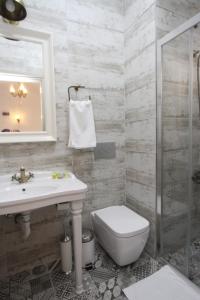 a bathroom with a toilet and a sink and a shower at Alya Mou Butik Hotel in Çeşme