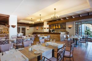 a restaurant with tables and chairs and a bar at Iberostar Selection Andalucia Playa in Chiclana de la Frontera