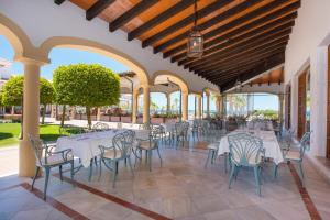 a restaurant with white tables and chairs on a patio at Iberostar Selection Andalucia Playa in Chiclana de la Frontera