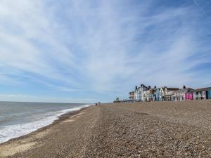 a sandy beach with houses and the ocean at Sleepers Cottage in Aldeburgh