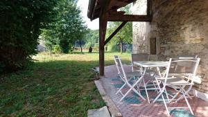 a table and chairs sitting next to a building at Maison Individuelle Les Templiers in Bure-les-Templiers