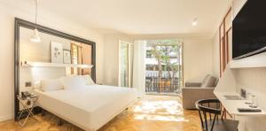 a white bedroom with a white bed and a desk at SH Ingles Boutique Hotel in Valencia