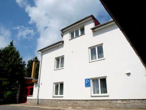 - un bâtiment blanc avec une porte rouge dans l'établissement Penzion Horinka Velké Losiny, à Velké Losiny
