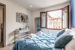 a bedroom with a blue bed and a window at Dreamy Guelfa in Florence