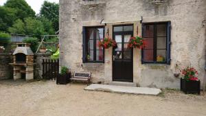 Recey-sur-Ource的住宿－瑞希奧爾斯家庭度假屋，两扇窗户和一扇鲜花门的房子