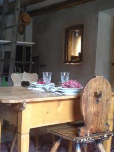 una mesa de madera con platos y vasos. en Le voyage d'UBUNTU en Heiligenstein