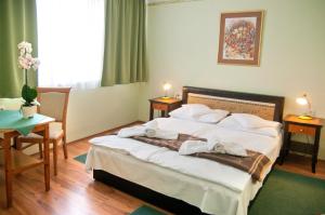 een hotelkamer met een bed met handdoeken erop bij Majerik Hotel in Hévíz