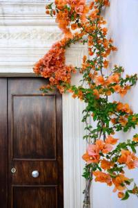 una corona de flores naranjas en una pared junto a una puerta en Il Giardino, en Grottaglie