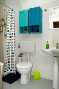 bagno con servizi igienici, lavandino e armadi blu di Il Giardino a Grottaglie