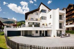 a white house with a fence in front of it at Appart's Platzl in Serfaus