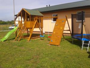 a playground with a house and a slide at Domkiuweroniki in Mielenko