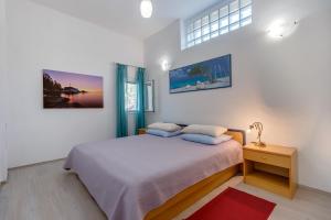 a bedroom with a bed and a table with a lamp at Holiday home Nikol in Veli Lošinj