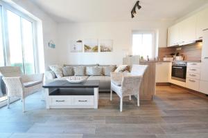 a living room with a couch and a table and chairs at Waldsiedlung DHH MeerSeenSucht in Korswandt