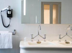 a bathroom with two sinks and a mirror at Hôtel Mercure Rodez Cathédrale in Rodez