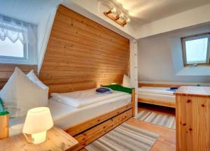 アールベックにあるAppartment Sonnenlandの木製の壁にベッド2台が備わる小さなベッドルーム1室