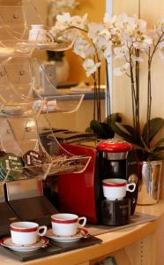基森的住宿－Sletz Parkhotel - Superior，一张桌子,上面放着咖啡杯、烤面包机和鲜花