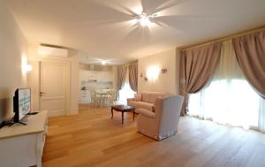 sala de estar con sofá y TV en Garda Apartments San Vigilio Golf en Pozzolengo