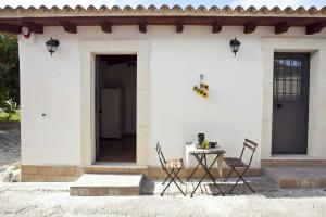 una casa blanca con una mesa y sillas frente a ella en casale in campagna, en Avola