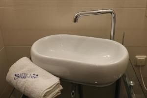 a white sink in a bathroom with a towel at Sletz Parkhotel - Superior in Gießen