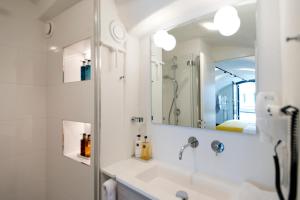
a bathroom with a sink, mirror, and bathtub at Hotel Oudegracht in Utrecht
