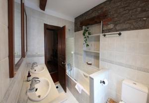 ein Badezimmer mit zwei Waschbecken und einer Toilette in der Unterkunft Casa de Aldea La Pumariega in Caces