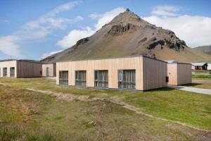 un edificio con una montagna sullo sfondo di Arnarstapi Hotel a Stapi