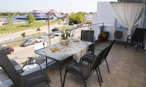 stół i krzesła na balkonie z widokiem na ulicę w obiekcie Athina Luxury Apartment w mieście Keramotí