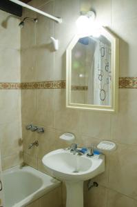 y baño con lavabo, espejo y bañera. en Departamento Loft, en medio de la ciudad en Mendoza