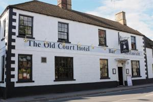 a white building with the old court hotel on the street at The Old Court Hotel in Witney