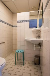 a bathroom with a sink and a toilet and a stool at Hotel Restaurant Taverne in Twello