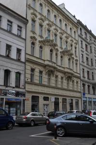 un gran edificio con coches estacionados frente a él en Apartment Josef, en Praga