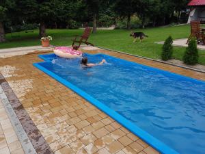 two children playing in a swimming pool with an inflatable at Cudowny Zakątek z Ogrodem i Basenem in Bukwica